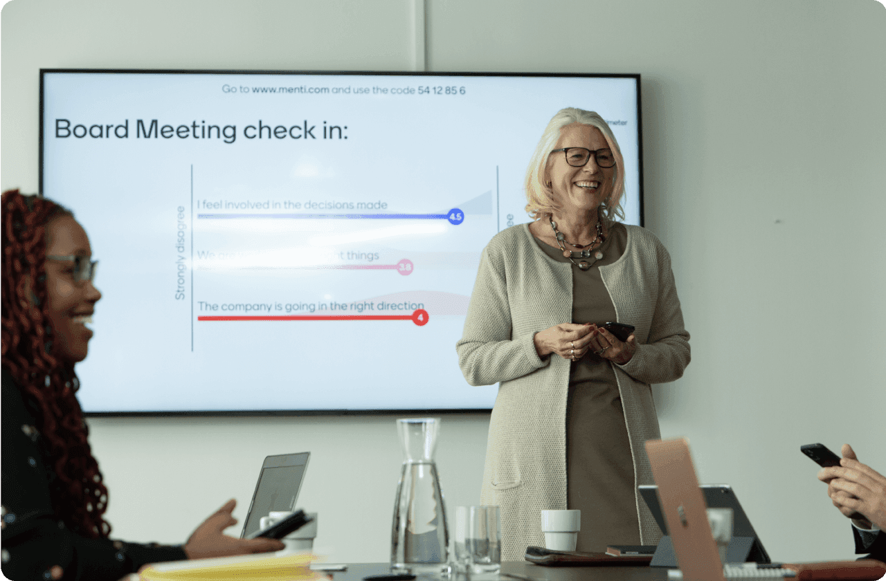 Woman presenting a board meeting check in using Mentimeter.
